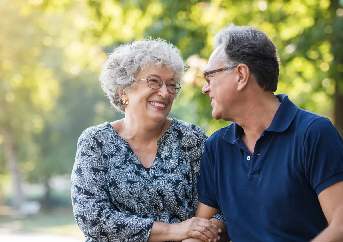 Mature couple smiling at each other in a park